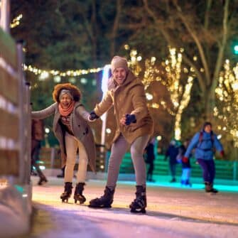 Jolly,Multiethnic,Couple,Enjoying,Night,Ice,Skating,Together